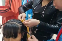 老师帮学生把头发梳成大人模样，关爱与引导，助力青春成长